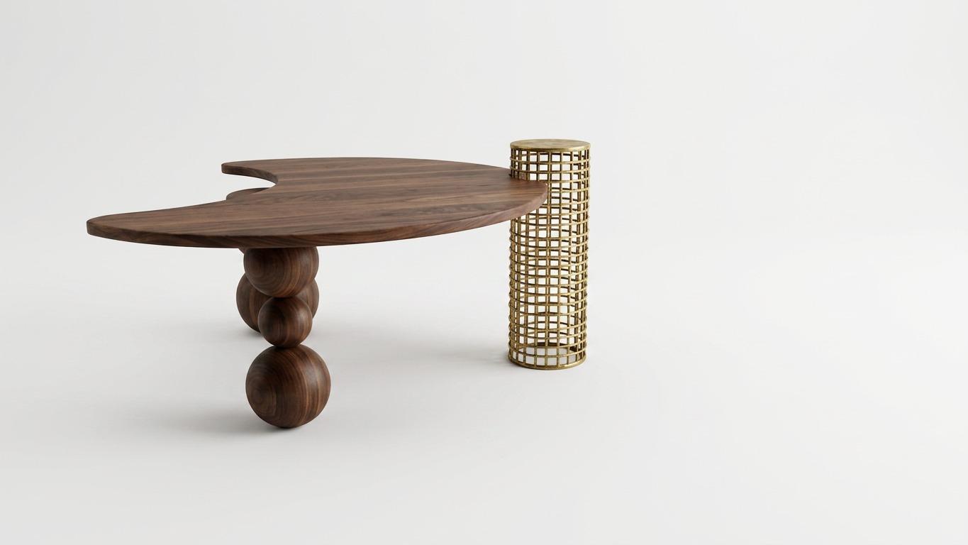 Low table with an organic walnut top on stacked walnut spheres and a woven brass cylinder.